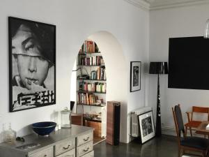 uma sala de estar com uma mesa e uma estante de livros em La maison d’arles em Arles