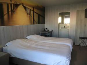 Un dormitorio con una gran cama blanca y una escalera en Hotel Chamdor en Roeselare