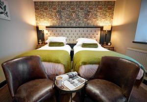 a hotel room with two beds and two chairs at The Fleece at Cirencester in Cirencester