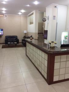 eine Lobby mit einem Wartezimmer und einer Rezeption in der Unterkunft Hotel Centenario Itajuba in Itajubá