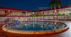 a swimming pool in front of a hotel at night at Express Inn & Suites - 5 Miles from St Petersburg Clearwater Airport in Clearwater