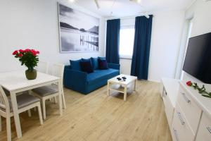 un soggiorno con divano blu e tavolo di Apartamenty Chwytowo 14 a Bydgoszcz