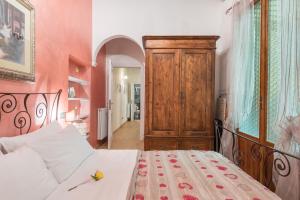 um quarto com uma cama e um armário de madeira em Ghibellina 22 Apartment em Florença