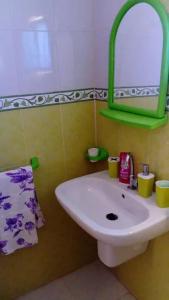 フーム・スークにあるBeltaief Residenceのバスルーム(白い洗面台、緑の鏡付)
