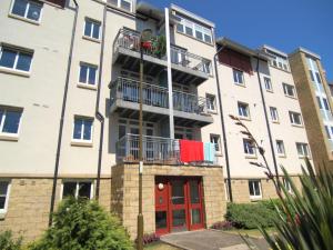 an apartment building with a red door and a balcony at Brunswick Apartments in Edinburgh