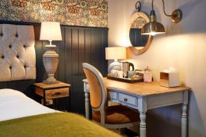 a bedroom with a desk with a bed and a lamp at The Fleece at Cirencester in Cirencester