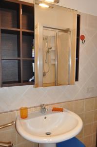 a bathroom sink with a shower and a mirror at Casa Bianca Del Centro in San Vito lo Capo