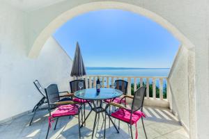 balcone con tavolo, sedie e vista sull'oceano di Stipe Residence a Podstrana