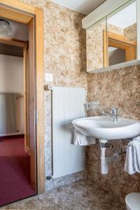 a bathroom with a sink and a mirror at Hotel Burgener in Saas-Fee