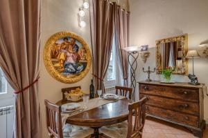 uma sala de jantar com uma mesa e um quadro na parede em Dante States Apartments em Florença