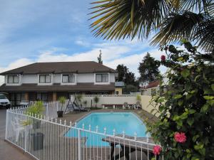 a house with a swimming pool in front of it at Palm City Motor Inn in Napier