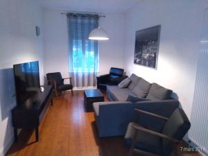 a living room with a couch and a tv at Appartement Meurisse in Metz