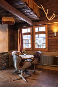 Zimmer mit einem Tisch, Stühlen und einem Fenster in der Unterkunft Hotel Burgener in Saas-Fee