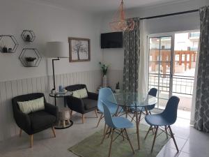 uma sala de jantar com uma mesa de vidro e cadeiras em Apartamento Monte Gordo em Monte Gordo
