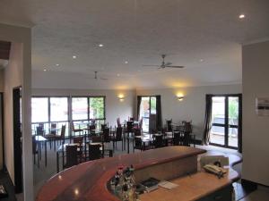 a restaurant with a bar and tables and chairs at Palm City Motor Inn in Napier