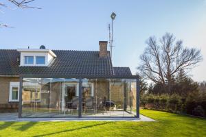 an extension to a house with glass doors at Bed & Breakfast Kroese in Oldenzaal
