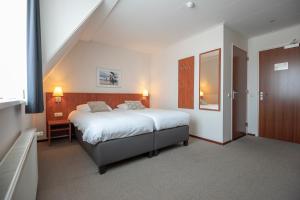 a bedroom with a large bed and a staircase at Hotel Royal in Noordwijk