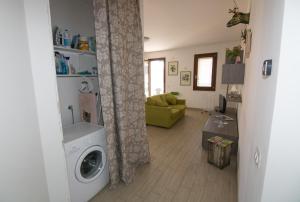 - un salon avec un lave-linge et un canapé dans l'établissement Appartamento Antonella a due passi dal centro e dal mare, à Grottammare