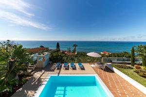 アルコ・ダ・カリェタにあるOurMadeira - Villa do Mar III, secludedのスイミングプール付きの家から海の景色を望めます。