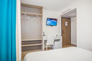 a bedroom with a bed and a desk and a monitor at Solesperit in Lloret de Mar
