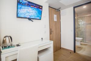 a bathroom with a toilet and a television on the wall at Solesperit in Lloret de Mar