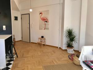 a living room with a pink flamingo painting on the wall at My Megaro Flat in Athens
