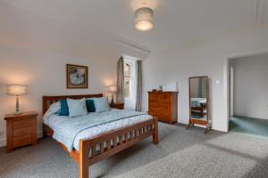a bedroom with a bed and a dresser and a mirror at Ardveich House, large Scottish estate home with loch & hill views in Lochearnhead