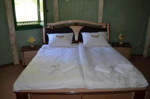 um quarto com uma cama com lençóis brancos e toalhas em Eco village Raj u raju em Konjic
