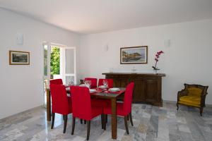 a dining room with a table and red chairs at Casa Sissi in Bellagio