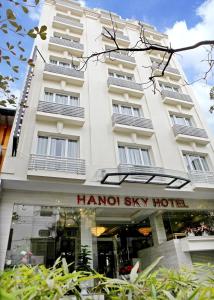 um grande edifício branco com uma placa em frente em Hanoi Sky Hotel em Hanói