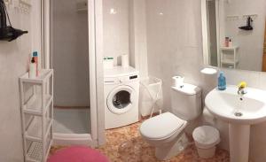 a bathroom with a toilet sink and a washing machine at "CASA ALICIA" Apartamento entero in Vecindario