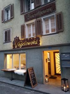 a store with a sign on the side of a building at Guesthouse Vögeliwohl in Fluelen