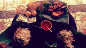 a table topped with different types of food on plates at Nakula's Guest House in Banyuwangi