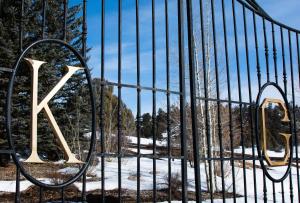 a gate with the letter k on it in the snow at The Guest House at Keyah Grande in Pagosa Springs