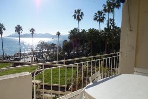 einen Balkon mit Blick auf das Meer und die Palmen in der Unterkunft Rocamare 2, by Welcome to Cannes in Cannes