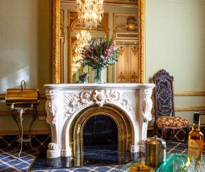 sala de estar con chimenea y espejo en Hotel Continental Palacete, en Barcelona