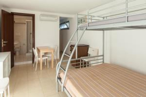 a bedroom with a bunk bed with a kitchen and a table at Camping & Residence Il Pioppeto in Vasto