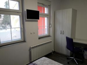 a room with a chair and a tv on the wall at Red House in Kyustendil
