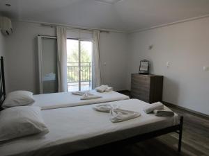 duas camas em um quarto com janela em Corfu Pearl em Liapades