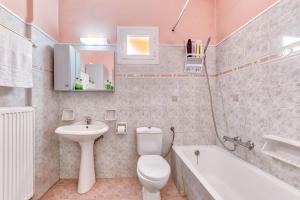 a bathroom with a toilet and a sink and a tub at Ina Apartment in Kalamaki +37 photos