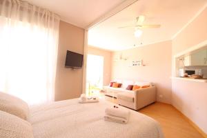 - une chambre blanche avec un lit et un canapé dans l'établissement Kumquat apartment, à Torrox Costa