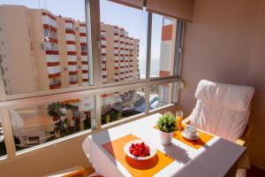 - une table avec un bol de fruits à côté d'une fenêtre dans l'établissement Kumquat apartment, à Torrox Costa