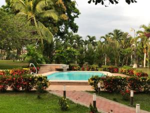 una piscina en un parque con flores en Hotel Los Higuerones, en Canoas