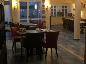 un comedor con mesas y sillas en un restaurante en Hotel Zur Post, en Geest