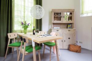 a dining room with a table with green chairs at Unique 3 floor apartment at Westerpark in Amsterdam