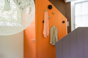 a hallway with an orange door and a towel at Unique 3 floor apartment at Westerpark in Amsterdam