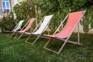 uma fila de cadeiras de jardim sentadas na relva em Decanting Porto House no Porto