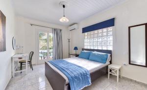 a bedroom with a bed with blue pillows and a desk at Ina Apartment in Kalamaki