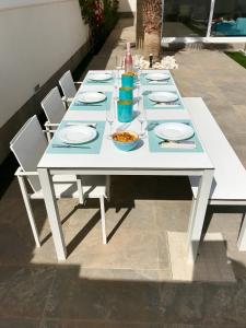 een witte tafel met borden en kommen met eten erop bij Villa Azul in San Pedro del Pinatar