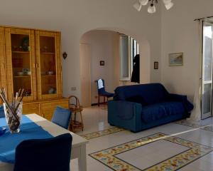 Una sala de estar con un sofá azul y una mesa. en Casa della Luna, en Amalfi